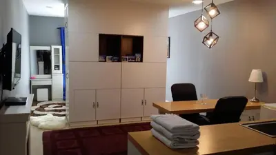 a room with a desk and a table with chairs at Champs Elysees in Kampar