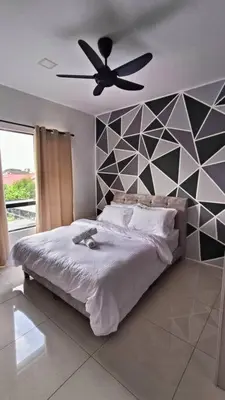 a bedroom with a bed and a ceiling fan at Honeyz Waterpark Homestay. in Ipoh