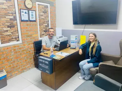 a man and a woman sitting at a desk at BRICKS Cameron Hostel in Tanah Rata