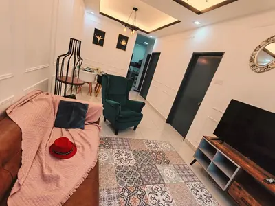 a living room with a couch and a television at WHITE ON HOMESTAY CAMERON BY ICOLOR in Tanah Rata