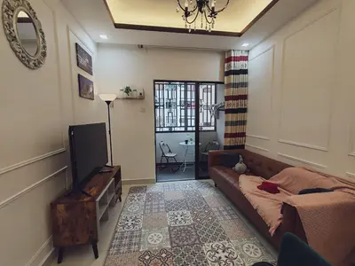 a living room with a couch and a television at WHITE ON HOMESTAY CAMERON BY ICOLOR in Tanah Rata
