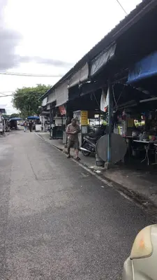 a man standing in front of a market with a building at BUTTERWORTH RAJA UDA RAYA HOMESTAY in Butterworth