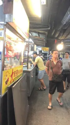 a group of people standing at a food stand at BUTTERWORTH RAJA UDA RAYA HOMESTAY in Butterworth