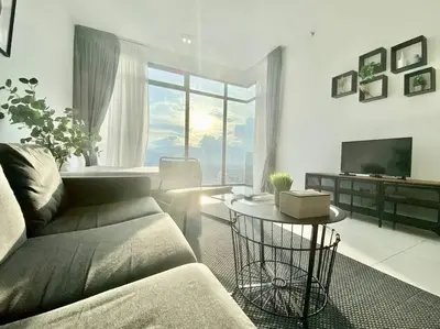 a living room with a couch and a table and a television at Beacon Executive Suites #Minimalist #SkyPool #Georgetown #6pax #2BR 2bath #3 Queen #Quality well maintained #Private host in George Town
