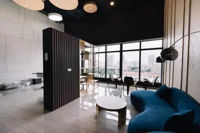 a living room with a blue couch and a table at NEW Infinity Pool 3 Bedrooms 2 Carparks 197 in Jelutong