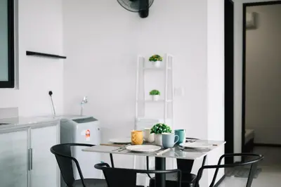 a kitchen with a table with chairs and a refrigerator at NEW Infinity Pool 3 Bedrooms 2 Carparks 197 in Jelutong