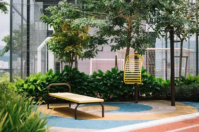 a bench and a yellow chair in a garden at NEW Infinity Pool 3 Bedrooms 2 Carparks 197 in Jelutong