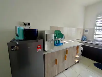 a kitchen with a refrigerator and a counter top at FIRASH HOMESTAY AT SERI ISKANDAR in Seri Iskandar