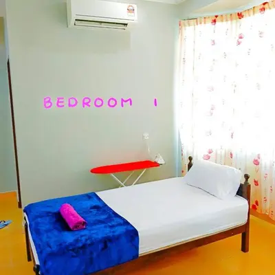 a bedroom with a bed with a blue blanket and a red table at Muslim Suite Home @ Airport Bayan Lepas Penang in Bayan Lepas