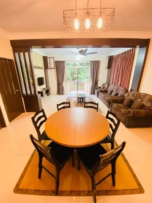 a dining room and living room with a table and chairs at Qaseh Homestay Cameron Highlands 3 in Brinchang