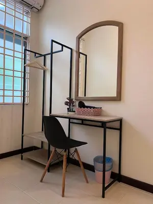 a desk with a mirror and a chair in a room at EE's Sunset House - Homestay 3 min walk to beach in Batu Ferringhi