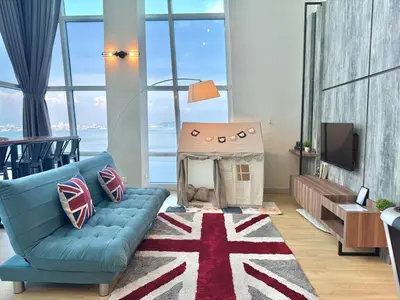 a living room with a blue couch and a dog house at Maritime Suite #Full Seaview #Pool Table #Hot Water Dispenser #Kids friendly #Georgetown #6pax #2BR2bath #Private host in Jelutong