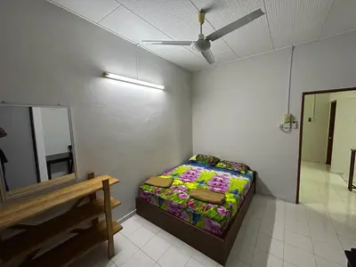 a small bedroom with a bed and a mirror at Muhibbah Homestay in Sungai Siput