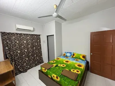 a bedroom with a bed and a ceiling fan at Muhibbah Homestay in Sungai Siput