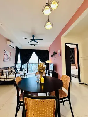 a dining room with a table and chairs and a living room at Urban Suites Homestay WL COSY in Jelutong
