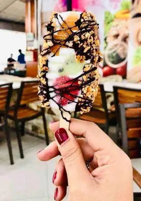 a hand holding a dessert with a butterfly on it at Cameron Highlands, The Breeze @ Barrington Square in Brinchang