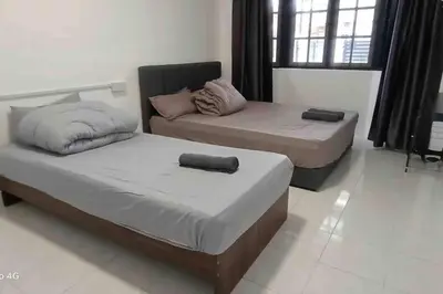 a bedroom with two beds and a couch at Diamond Bay Homestay in Teluk Intan