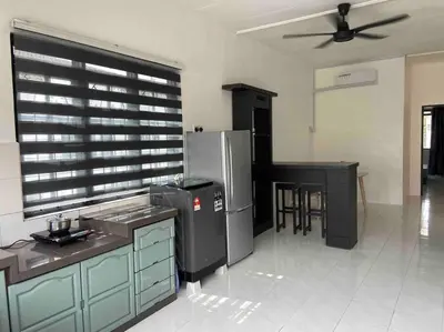 a kitchen with a refrigerator and a table and chairs at Diamond Bay Homestay in Teluk Intan