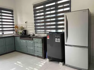 a kitchen with a refrigerator in the middle of it at Diamond Bay Homestay in Teluk Intan