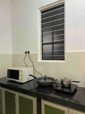 a kitchen counter with a microwave and a bowl on a stove at Homestay 2 @Taman Teluk Intan in Teluk Intan
