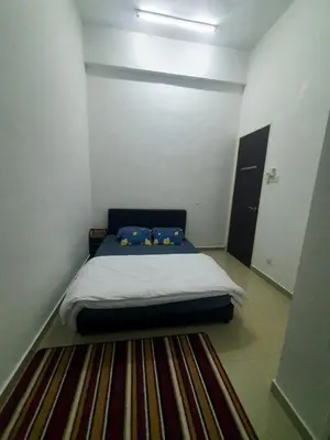 a bed in a small room with a rug at Homestay Pohon Rendang in Balik Pulau