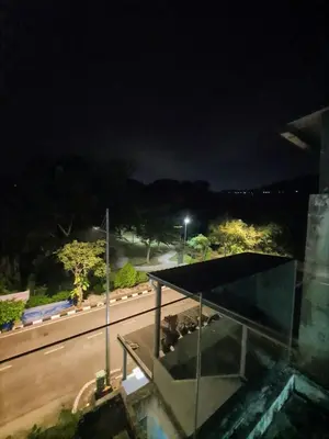 a night view of a building with a view of a street at Homestay Pohon Rendang in Balik Pulau