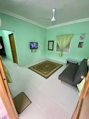 a living room with a couch and a tv at Rumah Comel in Kampung Degong