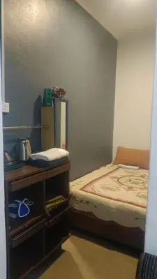 a small bedroom with a bed and a table at Mini Studio in Permatang Pauh