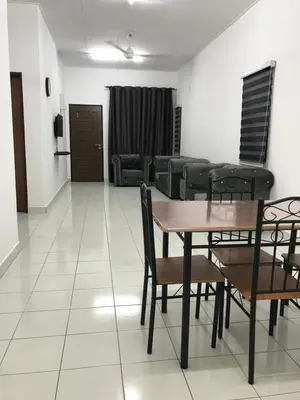 a living room with a table and chairs and a couch at Al Ghazali Homestay in Seri Iskandar