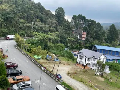 a street with cars parked on the side of a road at Hanna Homestay Apartment for Muslim in Tanah Rata