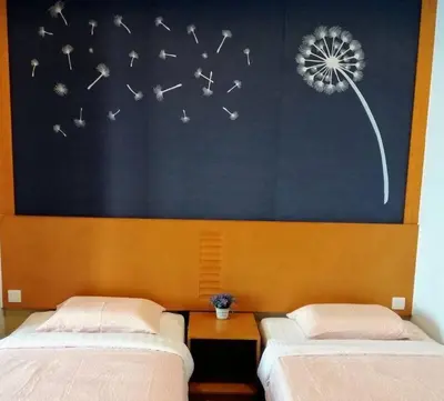 two beds in a room with a painting of a dandelion at Cameron Square, Nova Highlands - 1BR Studio Suite in Brinchang