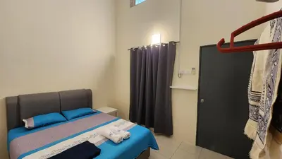 a bedroom with a bed and a black curtain at Homestay LK in Sitiawan