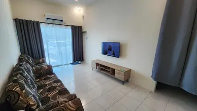 a living room with a couch and a tv on a wall at Homestay LK in Sitiawan