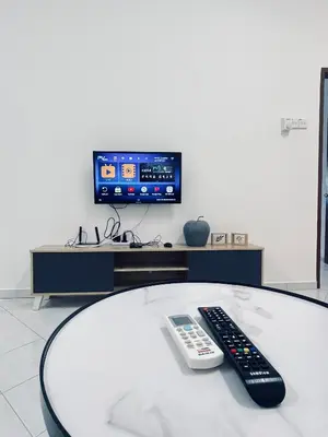 a remote control sitting on a round table with a tv at Comfort Semi D House, 1 min to Town by Mr Homestay in Teluk Intan