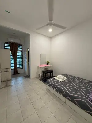 a bedroom with a bed and a table in it at Mikhail's Homestay in Sungai Petani