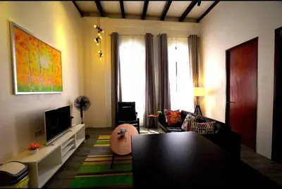 a living room with a couch and a tv at Ipoh Old Town Heritage Family Suite-6R4B -12-16pax in Ipoh