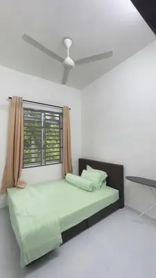 a bedroom with a bed with a ceiling fan at Tok Abah Homestay Bukit Mertajam in Bukit Mertajam