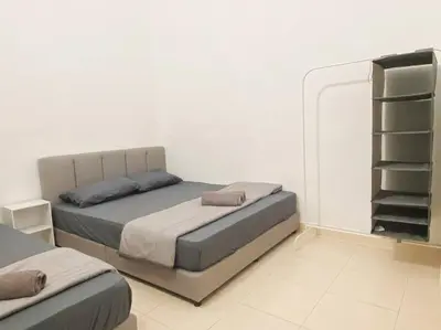 a white room with a bed and a closet at Warm and Cozy in Teluk Intan