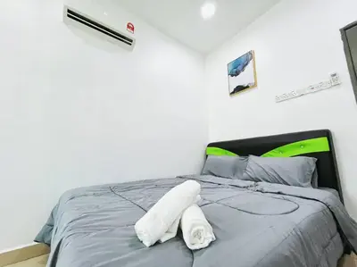 a bed with a white towel laying on it at KawanMu House with 6 Bedrooms in Taiping
