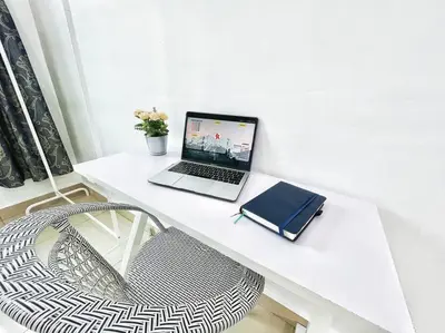 a laptop computer sitting on a white desk with a chair at KawanMu House with 6 Bedrooms in Taiping