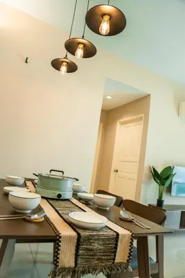 a dining room table with bowls and plates on it at Stylish River-View Apartment In Ipoh in Ipoh