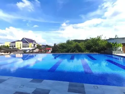 a large swimming pool with blue water at Stylish River-View Apartment In Ipoh in Ipoh