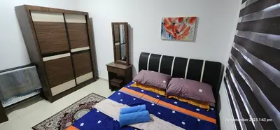 a bedroom with a bed with purple pillows at D'Haty Homestay in Padang Serai