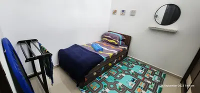 a small bed in a room with a mirror at D'Haty Homestay in Padang Serai