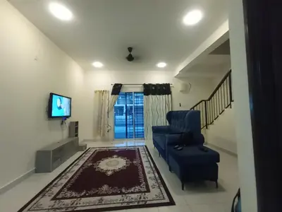 a living room with a blue chair and a television at A&H Homestay Teluk Senangin in Segari