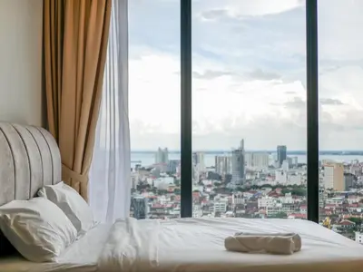 a bed in a room with a large window at Beacon Executive Suite by Uptrend Home Management in George Town