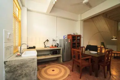 a kitchen with a table and a stainless steel refrigerator at Shophouse Studio in George Town