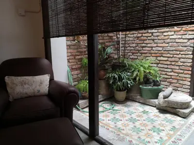 a living room with a chair and a brick wall at Shophouse Studio in George Town