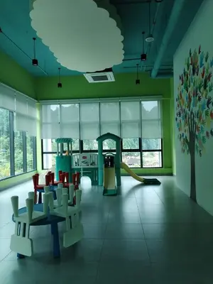 a room with a playground with chairs and a slide at Sunway Onsen Suites beautiful view in Kampong Batu Lapan