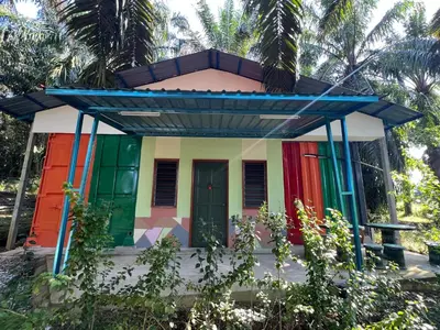 a colorful house in front of some trees at Slim Village Palm House - 2 rooms, 8 beds, 8 persons in Slim River
